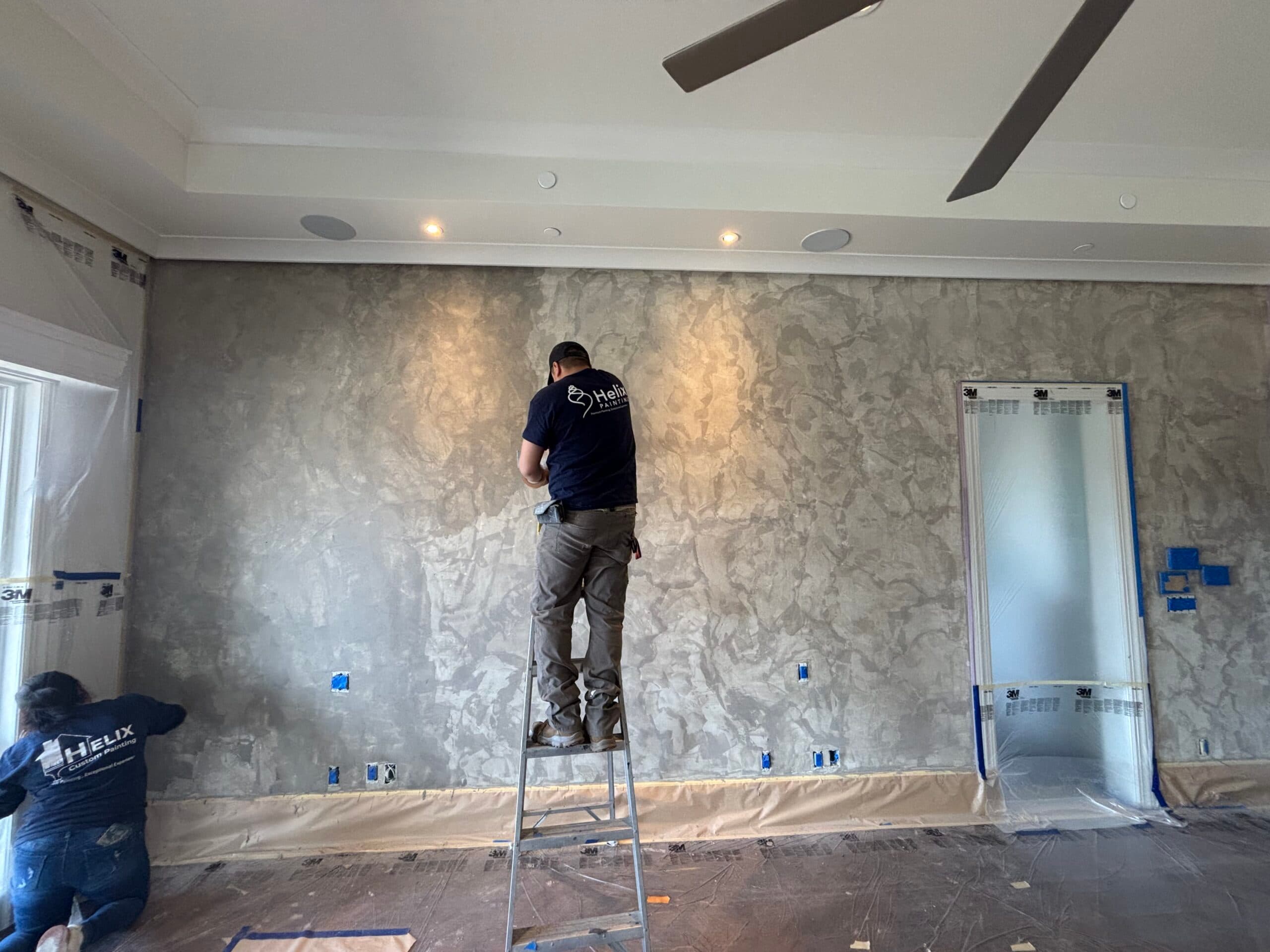 Helix Painting crew finishing a plaster feature wall over protected floors