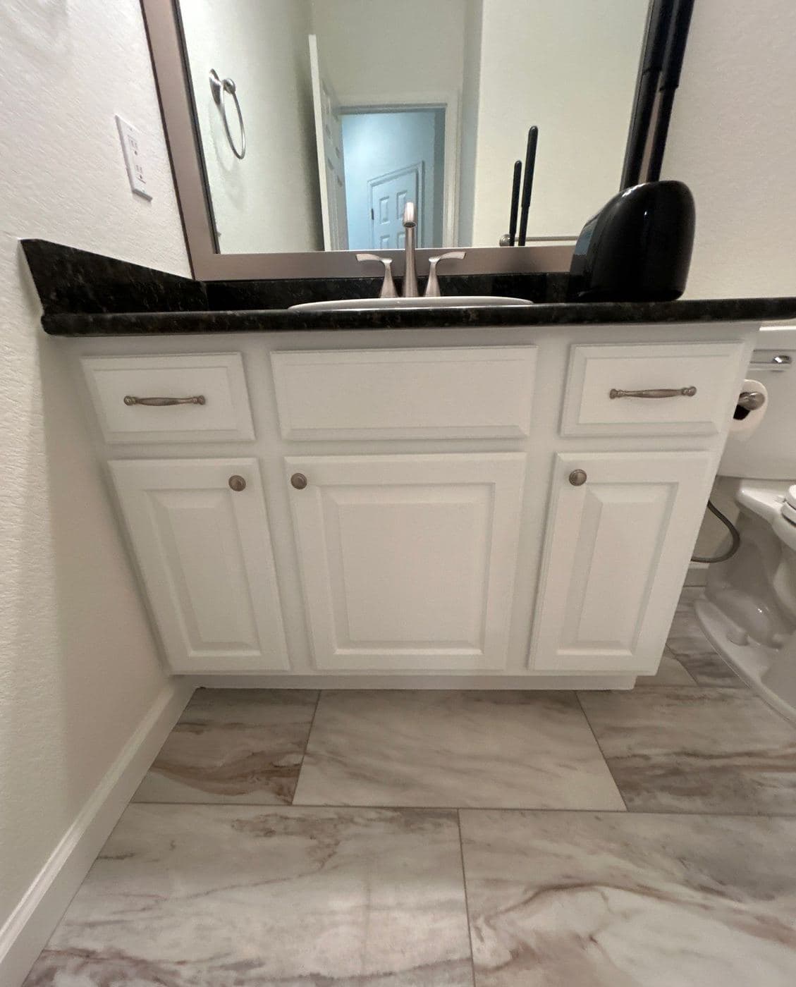 Bathroom vanity refinished in white with a dark stone top