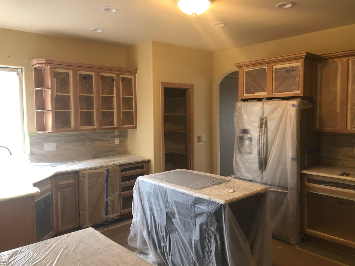 Oak kitchen masked and sheeted before the respray starts
