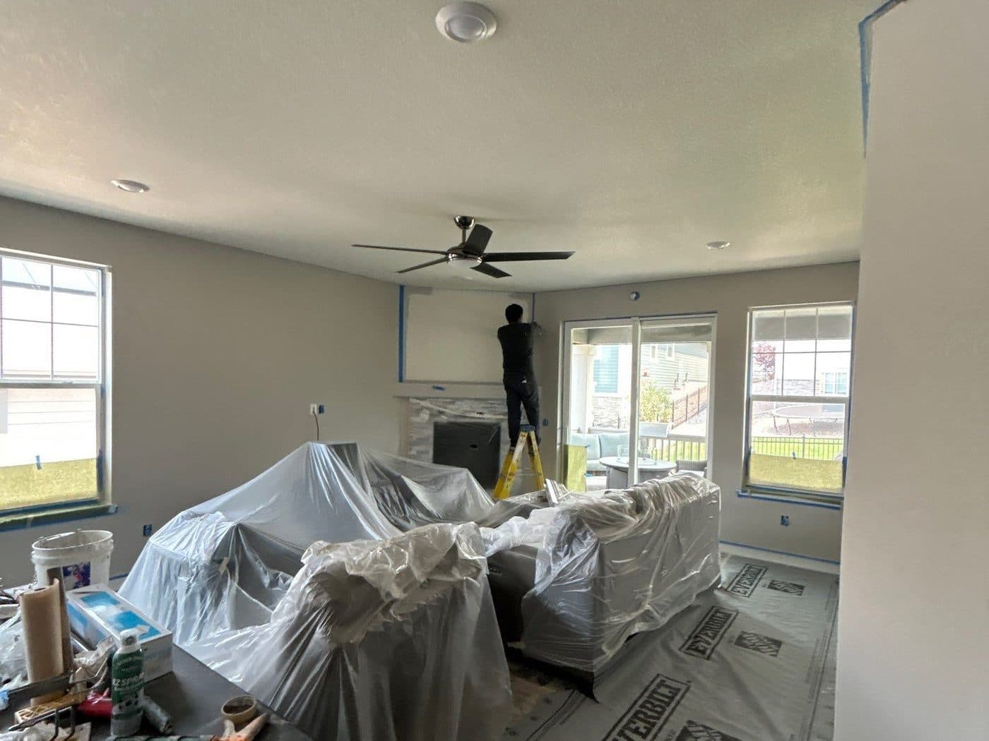 Living room with furniture covered and walls prepped