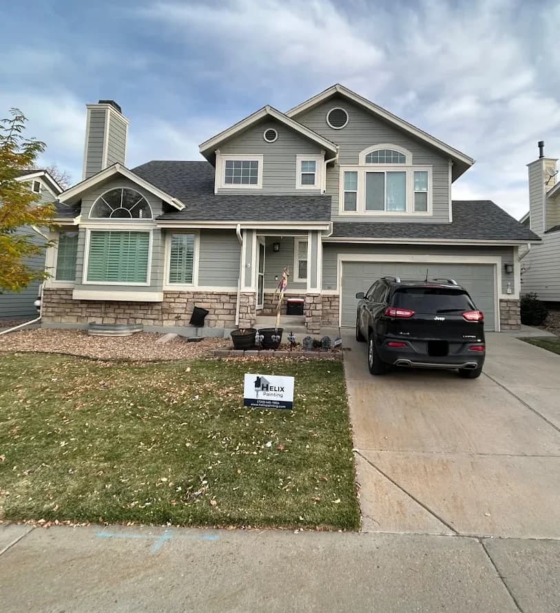 Gray two-storey home with cream trim and a stone base
