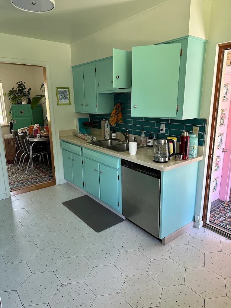 Teal kitchen cabinets with a tiled backsplash