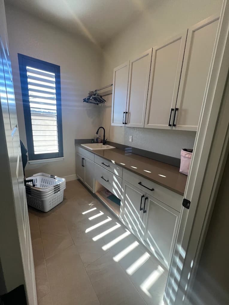 Galley kitchen with white cabinetry in full sunlight