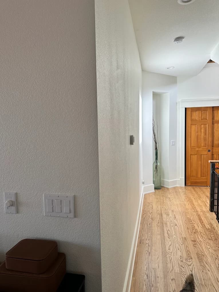 Hallway repainted in warm white with a timber door