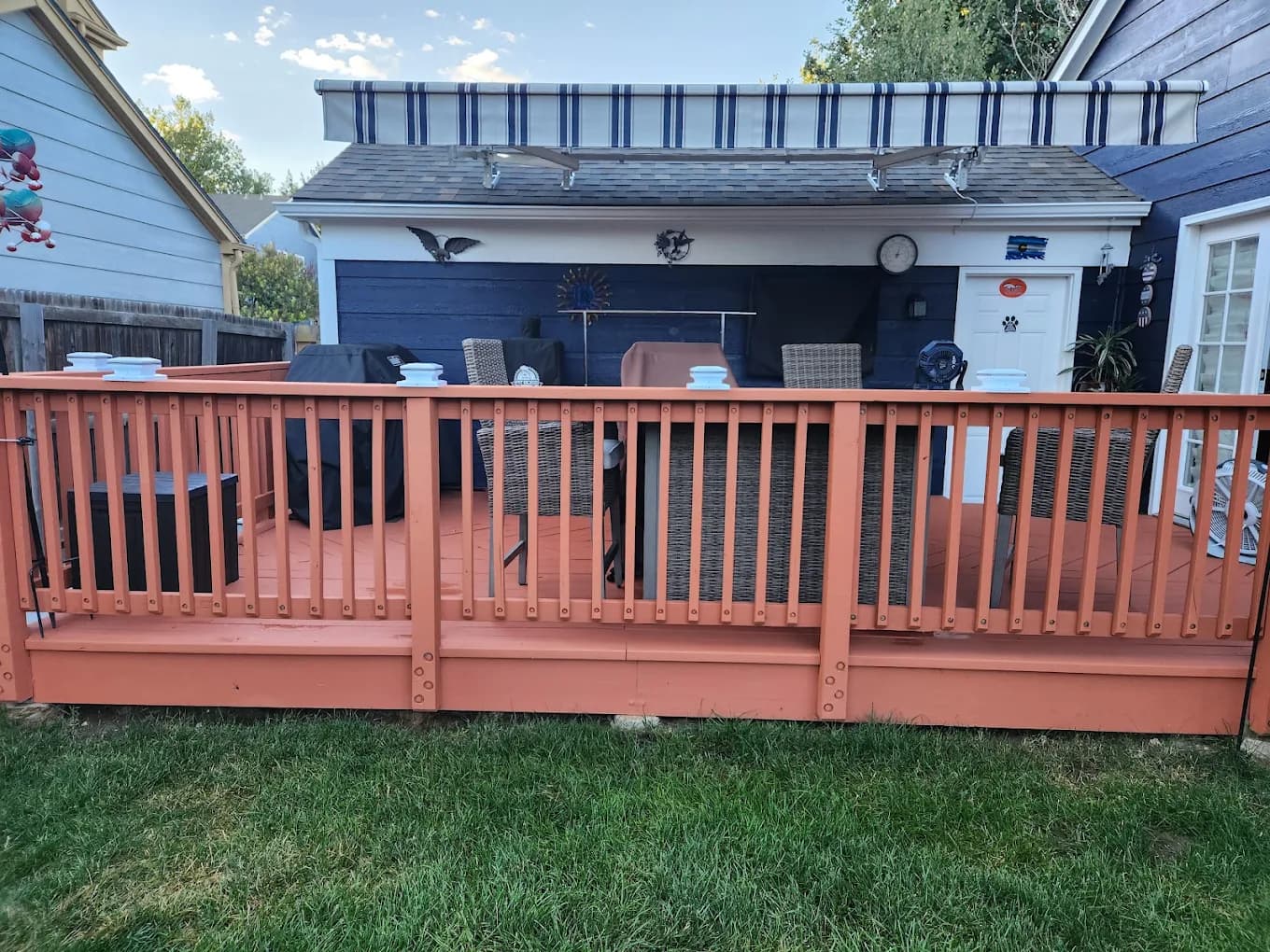 Red-brown stained fence and railing along a back yard