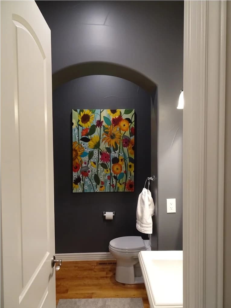 Powder room finished in a deep charcoal with white trim