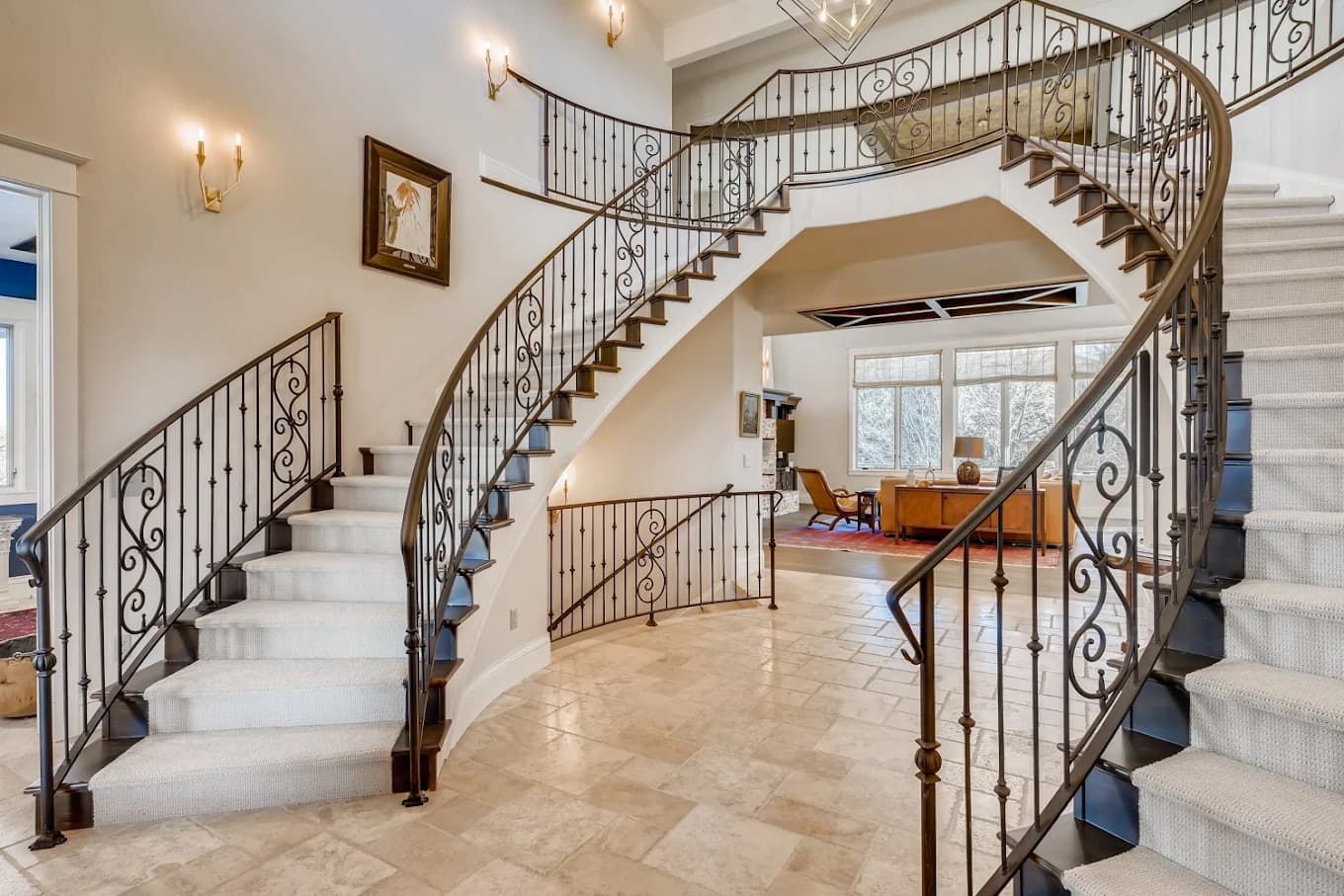 Curved staircase with an iron balustrade and repainted walls