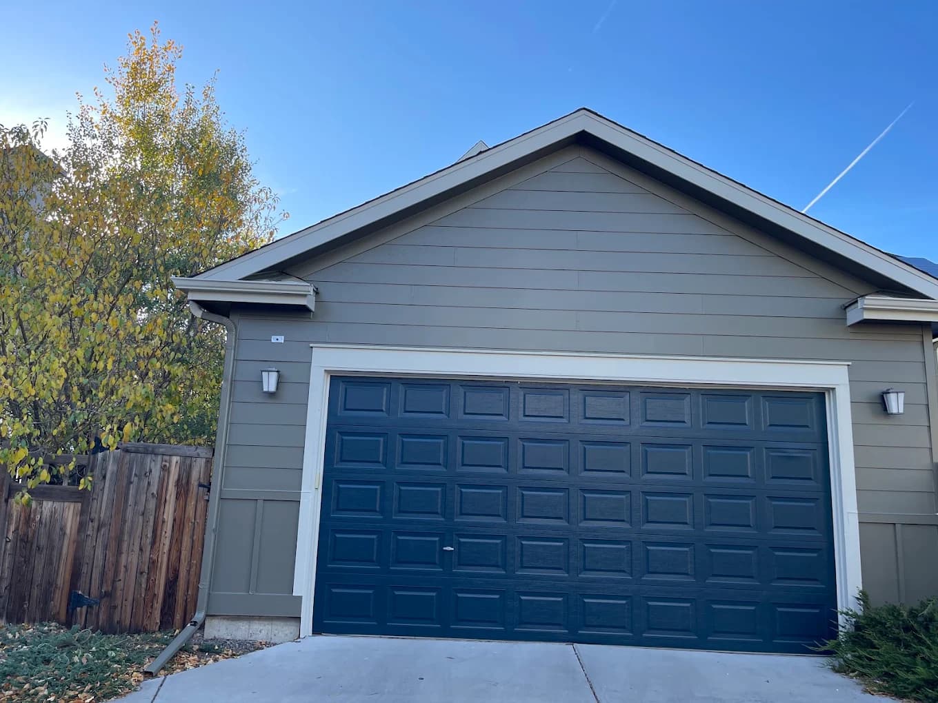 Pale blue home with a deep navy garage door