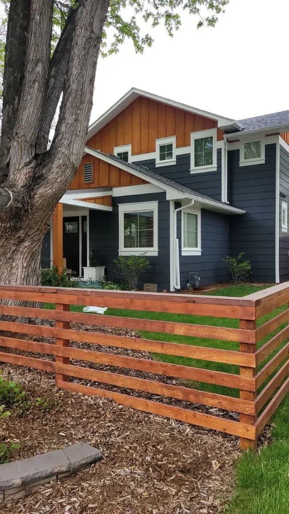 Modern horizontal slat fence beside a repainted home