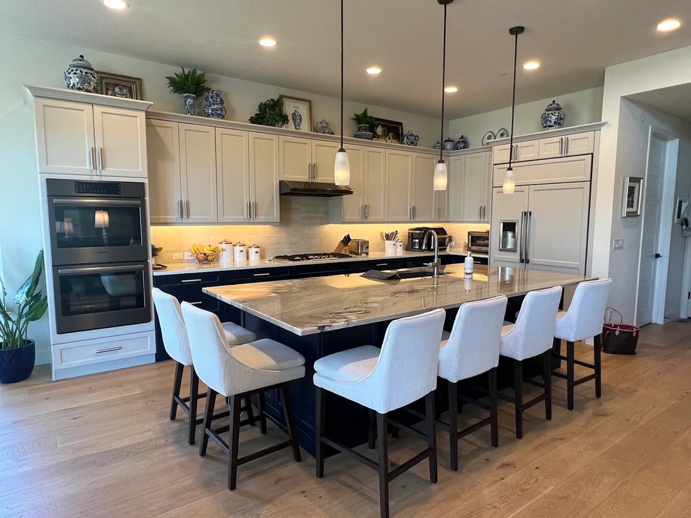 Large white kitchen with double ovens and an island