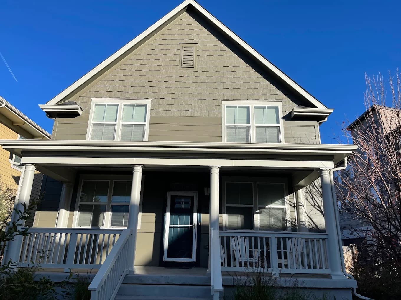 Gray home with a white porch and painted railings
