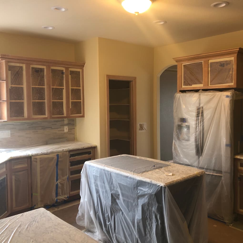 Kitchen island and cabinetry sealed under plastic sheeting