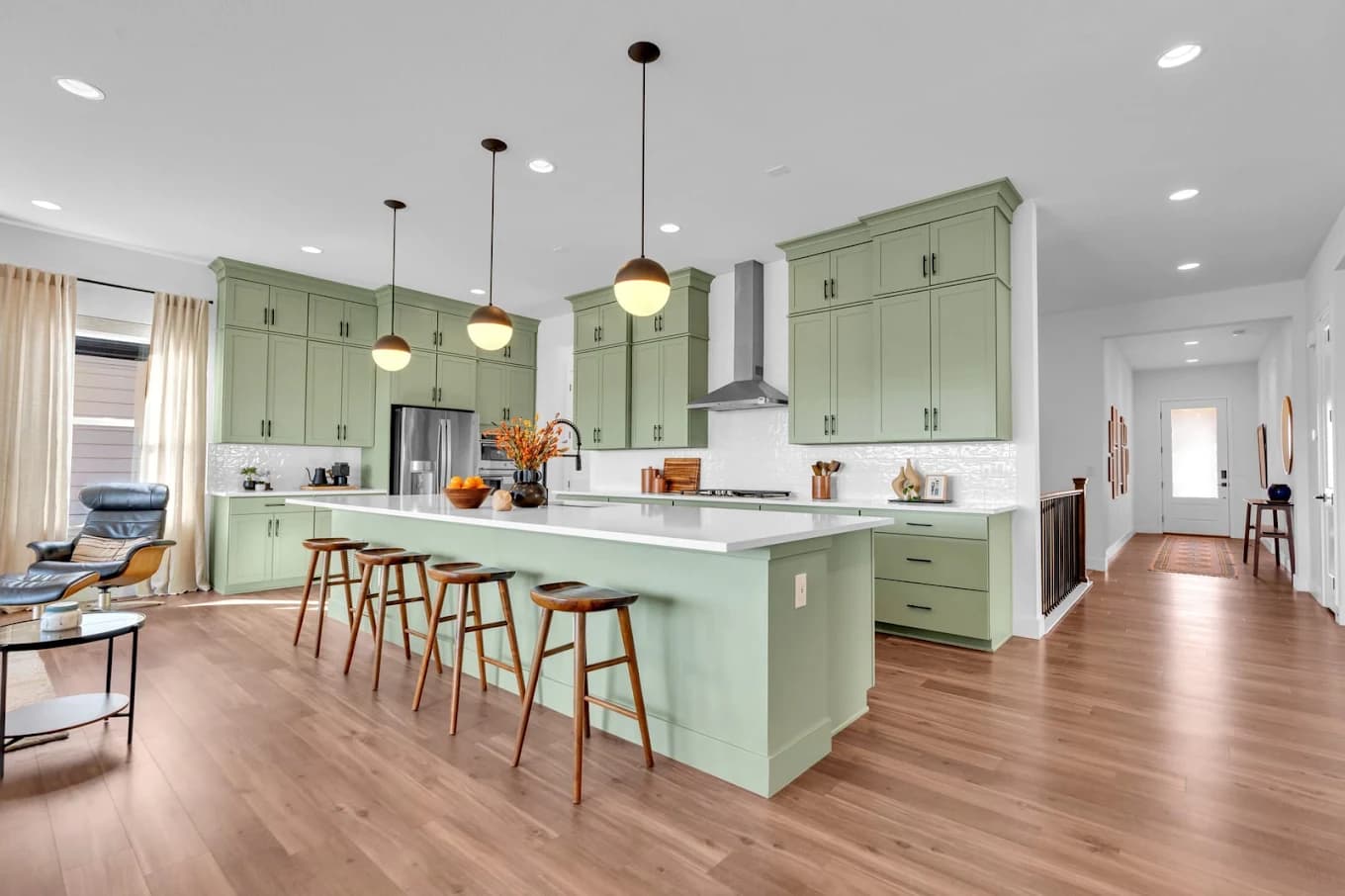 Sage green kitchen cabinetry with a white island