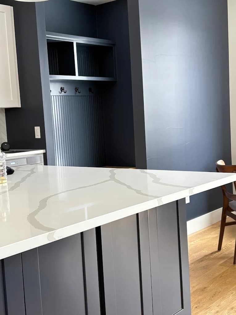 Kitchen with a flat painted ceiling above a navy island