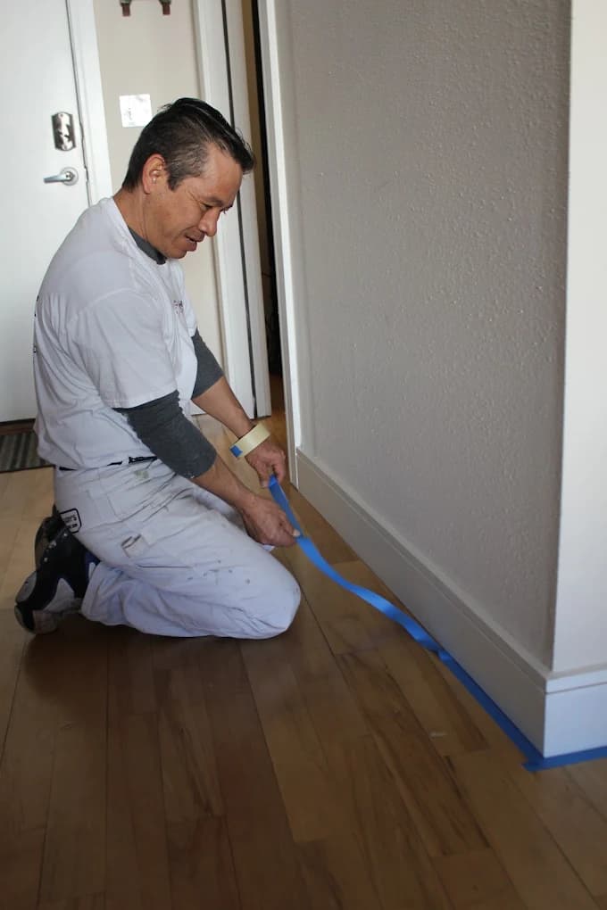 Painter masking a doorway before cutting in