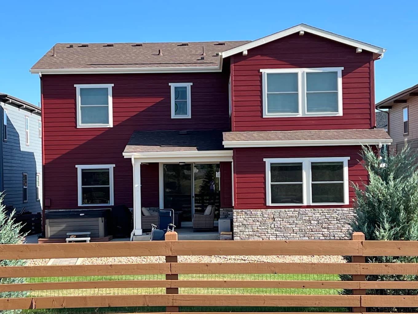 Red-sided home with a modern slat fence after a full repaint