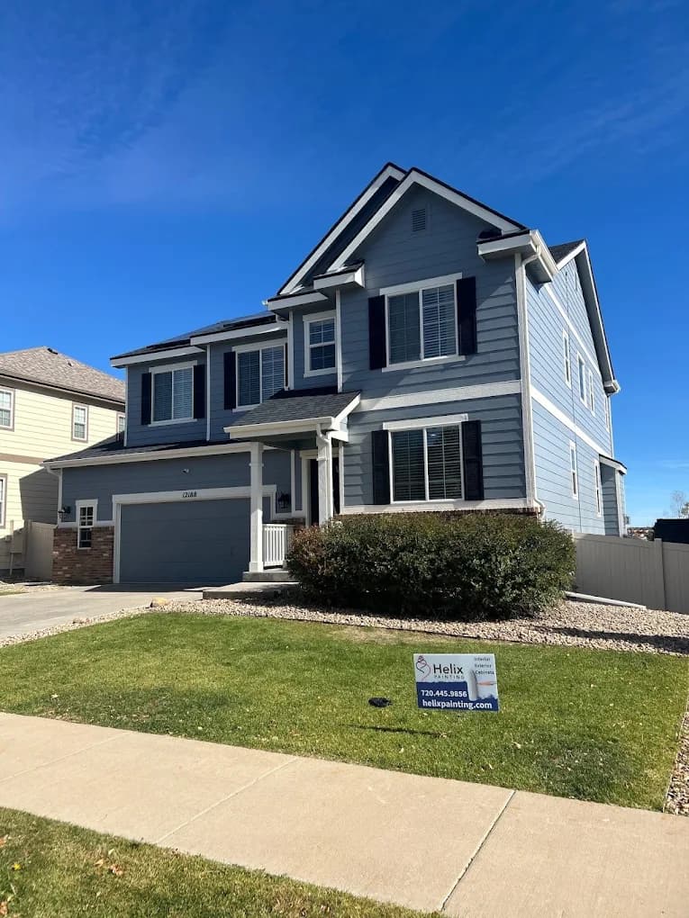 Blue-gray two-storey home with a Helix Painting sign in the yard