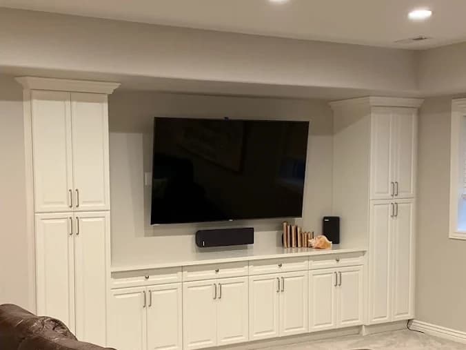 The same built-ins refinished in soft cream with a media wall