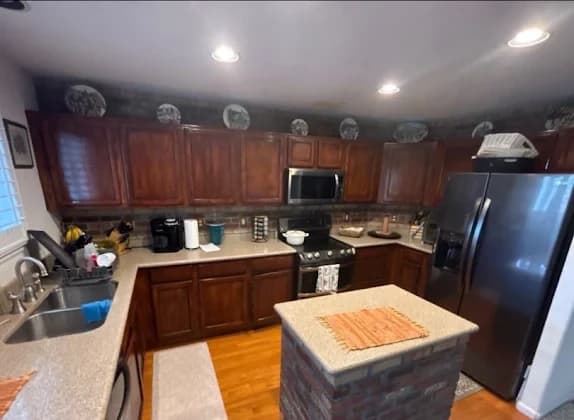 Kitchen with dark cherry cabinets and a brick backsplash