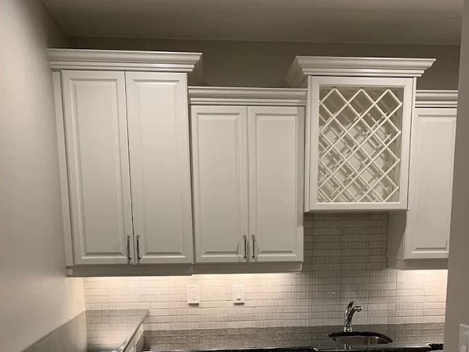 The same kitchen with the cabinets resprayed white and a new backsplash