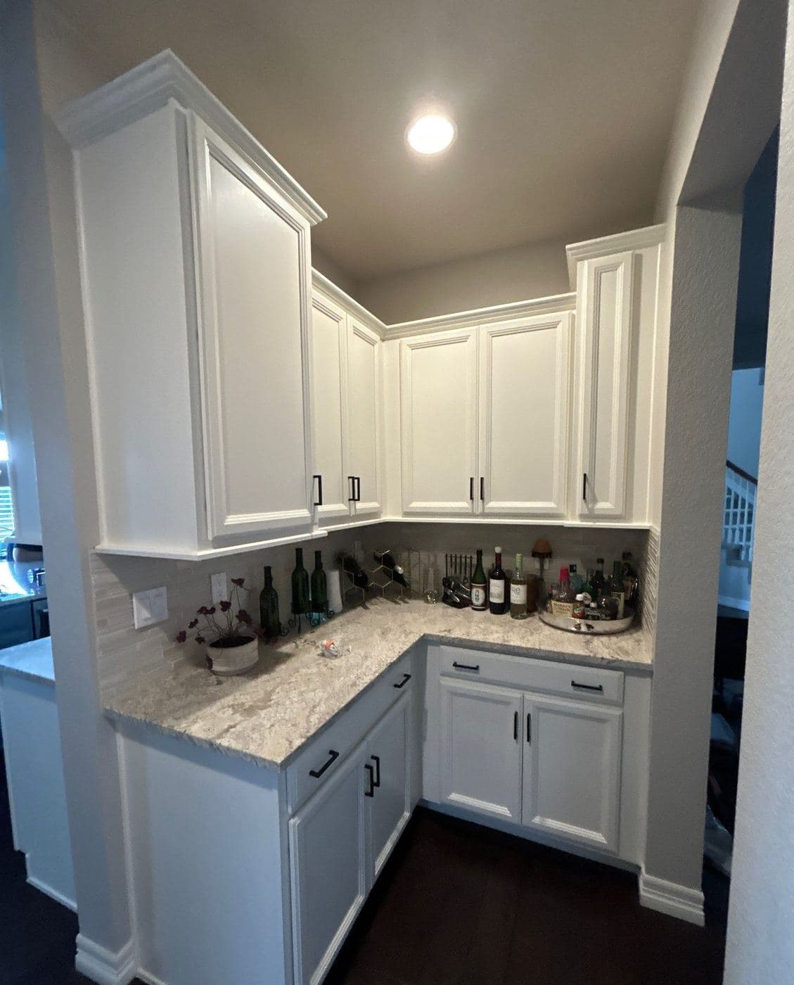 White upper and lower cabinets with a stone countertop