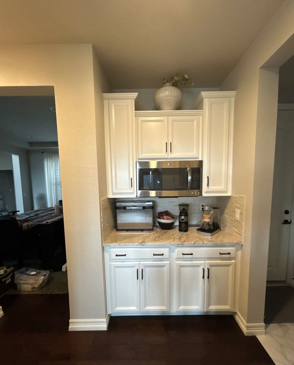 White kitchen cabinetry around a built-in microwave