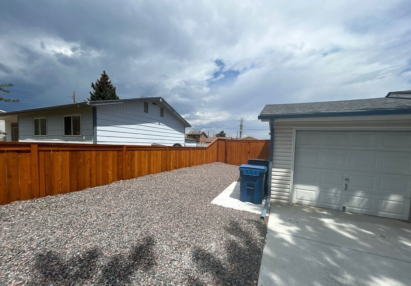 Stained privacy fence enclosing a gravel back yard