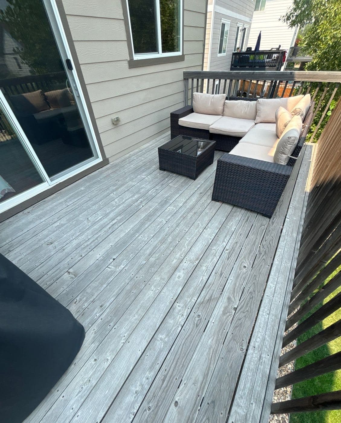 Gray stained deck with outdoor seating against the house
