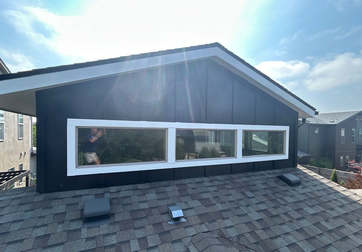 Black-painted gable and white window trim seen from the roofline