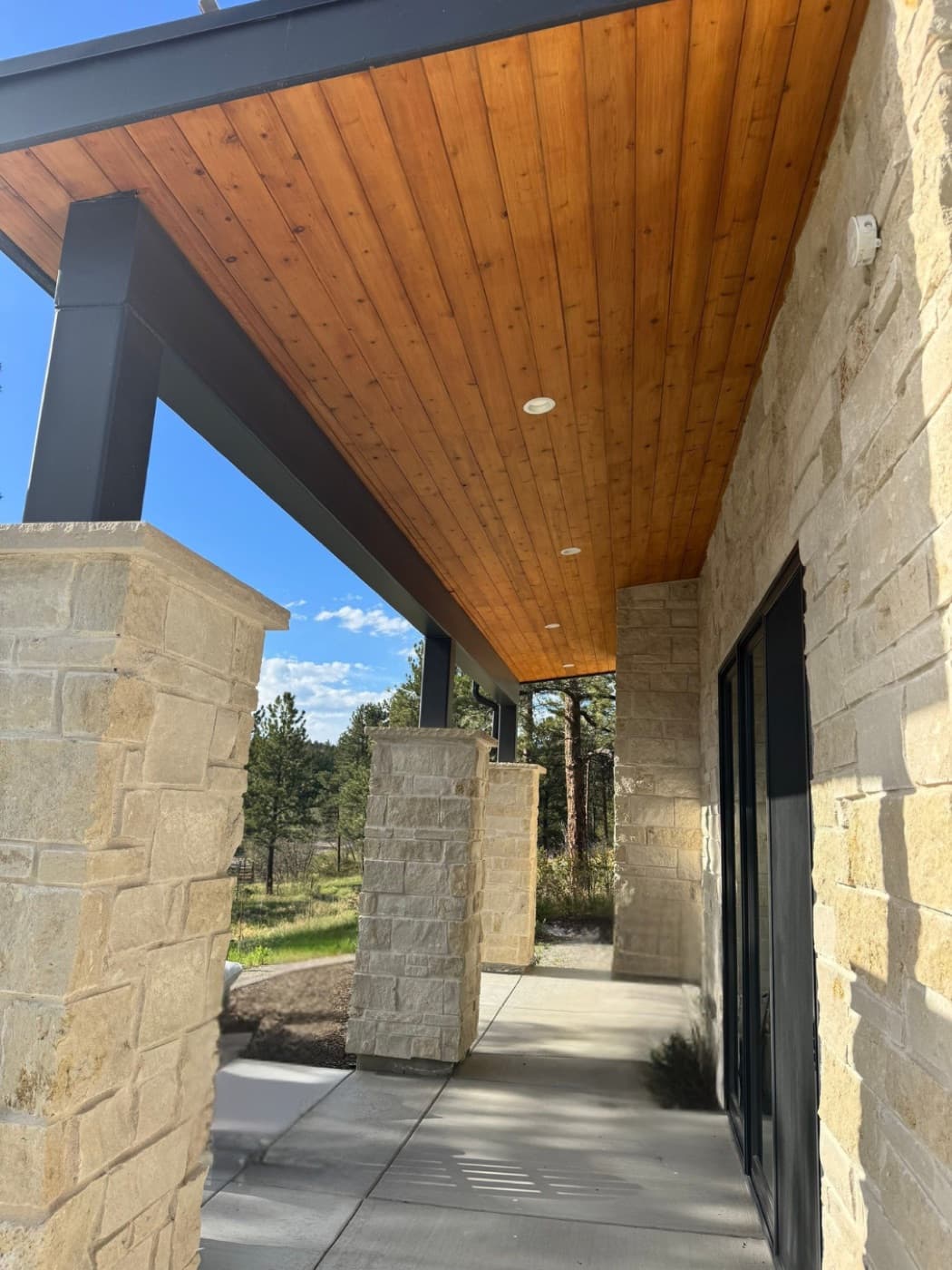 Covered patio with a freshly stained tongue-and-groove cedar ceiling